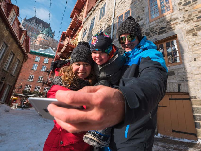 A family photograph themselves in the snowy Petit-Champlain district, with the Château Frontenac in the background.