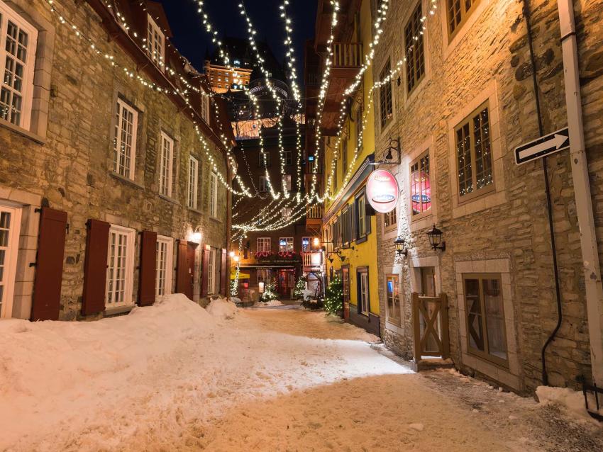 La rue du Cul-de-Sac enneigée dans le quartier Petit-Champlain avec des décorations de Noël et du temps des fêtes.