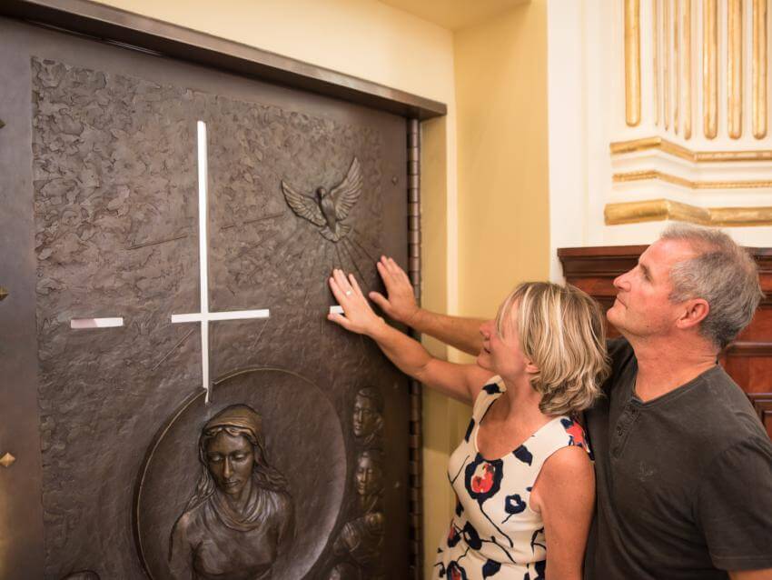 A man and a woman touching the Holy Door