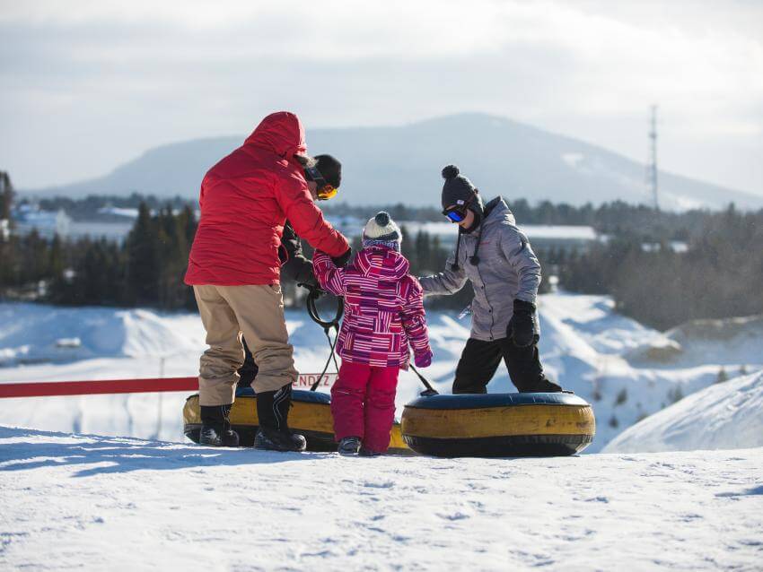 Une famille s'apprête à glisser au centre de jeux d'hiver du Village Vacances Valcartier.