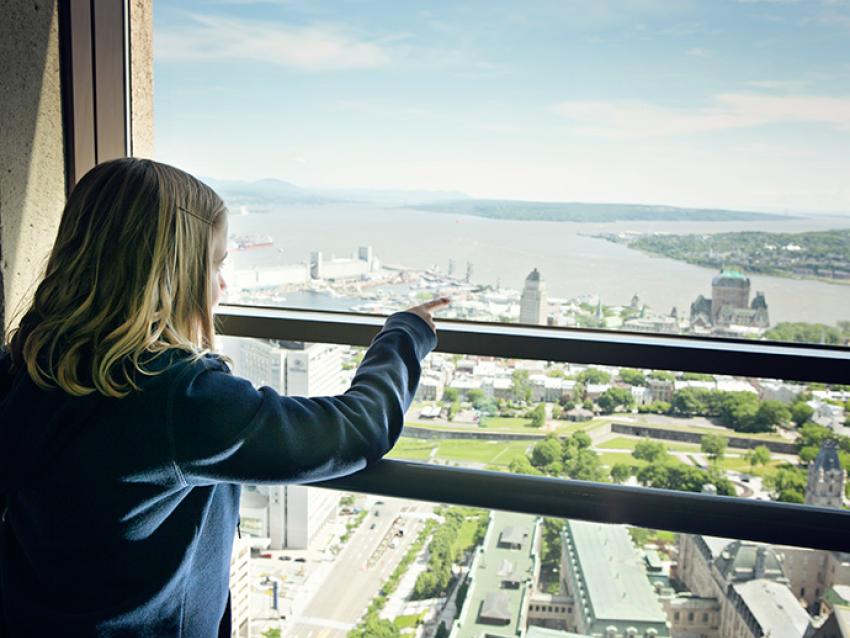 A young girl observes the view of Québec City from the Observatoire de la Capitale.