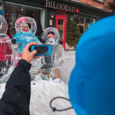 A family takes pictures with the ice sculptures in the Petit-Champlain district, during the Québec Winter Carnival.