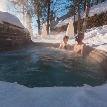 Un couple relaxe dans un spa nordique, en hiver.