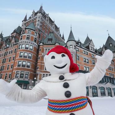 Bonhomme Carnaval poses proudly on the snow-covered Dufferin terrace, in front of the Château Frontenac.