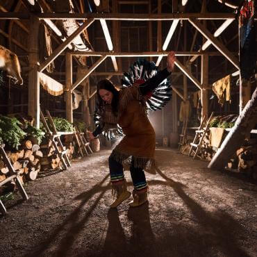 Une danseuse amérindienne performe une danse traditionnelle à l'intérieur de la maison longue à Wendake.