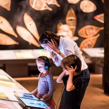 A mother and two children participate in an interactive exhibition at the Musée de la civilisation.