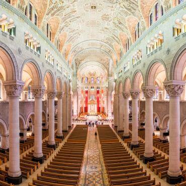 Impressive view of the interior of the Sanctuary of Sainte-Anne-de-Beaupré with its columns and detailed ceiling.