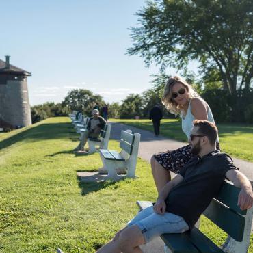 Couple assis dehors sur un banc, près de la tour Martello 1, sur les plaines d'Abraham.
