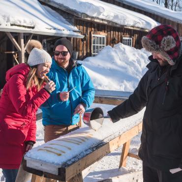 Maple taffy served to a couple at the sugar shack