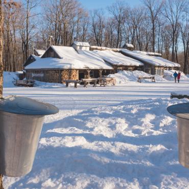 Boilers that collect maple water in front of a sugar shack
