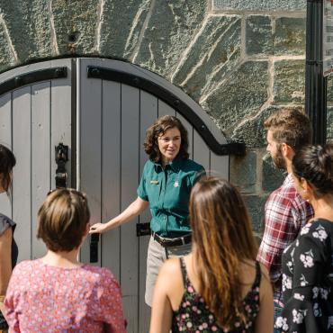 Un guide touristique avec un groupe de visiteurs devant les fortifications 