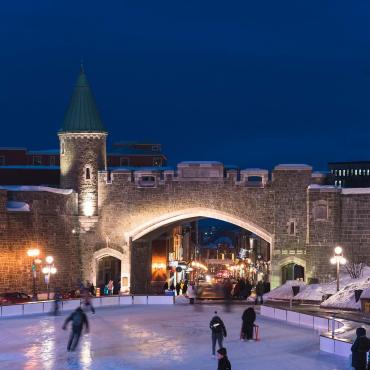 Porte Saint-Jean illuminée en soirée et patinage à la patinoire de la place D'Youville.